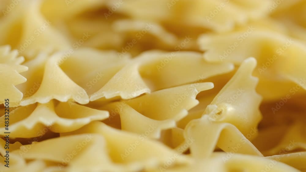 Farfalle, bow tie shaped dry pasta in rotation.Studio shot. Close Up, background.Stack of Dry uncooked farfalle Farfalle, bow tie shaped dry pasta in rotation.Studio shot. Close Up, background.Stack of Dry uncooked farfalle