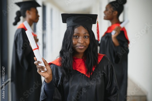 portrait of multiracial graduates holding diploma