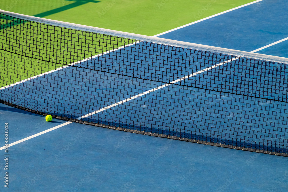 Artificial tennis court. View of the ball lying at the net. Very bright colors Artificial tennis court. View of the ball lying at the net. Very bright colors