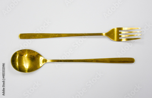 top view of gold spoon and gold fork