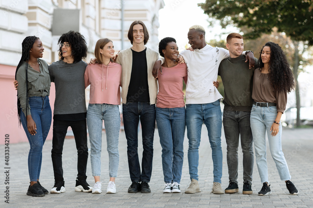 Multiracial group of happy millennial men and women outdoors, panorama Multiracial group of happy millennial men and women outdoors, panorama