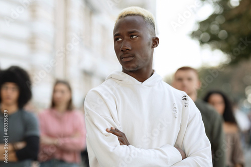 Confident black guy leader standing over multiracial group of millennials