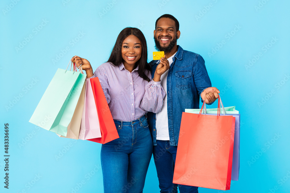 Portrait of happy black couple holding credit card and bags Portrait of happy black couple holding credit card and bags