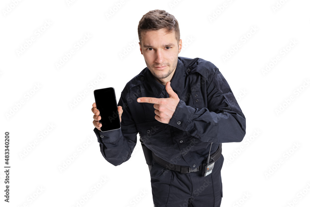 Portrait of young man, policeman officer wearing black uniform using phone isolated on white background. Concept of job, caree, law and order. Portrait of young man, policeman officer wearing black uniform using phone isolated on white background. Concept of job, caree, law and order.