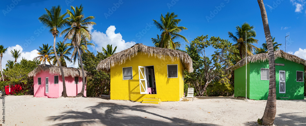 Isla Catalina, bunte Häuser zwischen Palmen am Strand der karibischen Insel in der Dominikanischen Republik, Panorama. - obrazy, fototapety, plakaty 