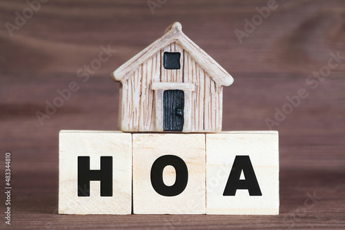 Miniature house on top of wooden blocks reading HOA photo