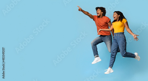 Thrilled african american couple looking at copy space