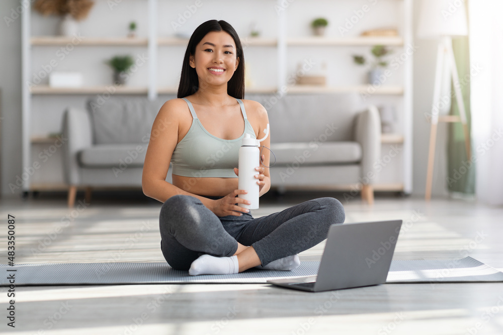 Portrait Of Smiling Young Asian Woman Training With Laptop Computer At Home