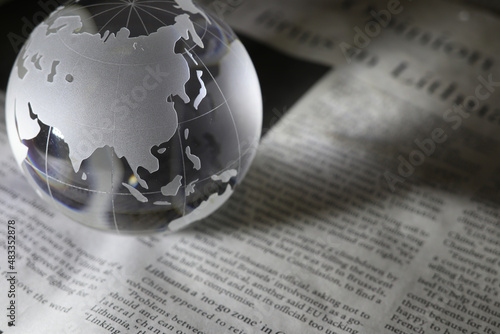 ガラスの地球儀と新聞　グローバルな事象のイメージ　glass globe(Asia and Oceania) on  newspapers photo