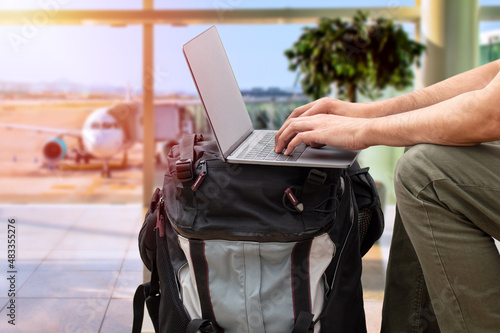 Fototapeta Cropped shot of an unrecognizable digital nomad sitting alone and typing on his