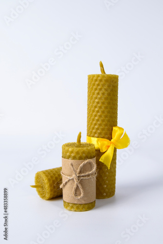 composition of three wax candles on a white background. natural beeswax. handmade candles