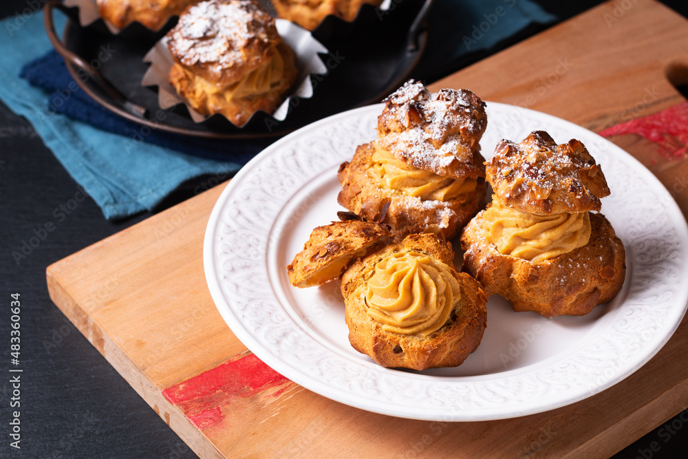 Food concept Homemade Caramel Choux a la cream or Choux cream puffs on dark background with copy space Food concept Homemade Caramel Choux a la cream or Choux cream puffs on dark background with copy space