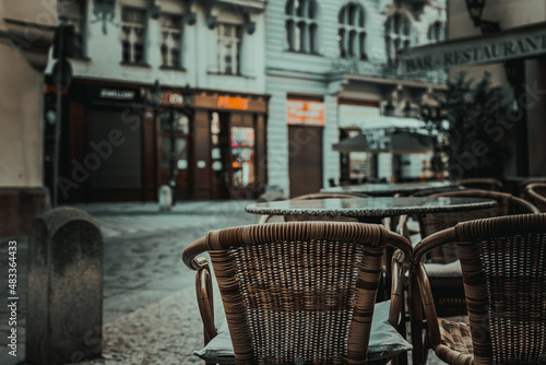 tables and chairs of a street restaurant in evening Prague