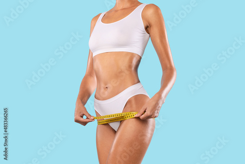Closeup of Unrecognizable Lady Measuring Hips With Tape photo