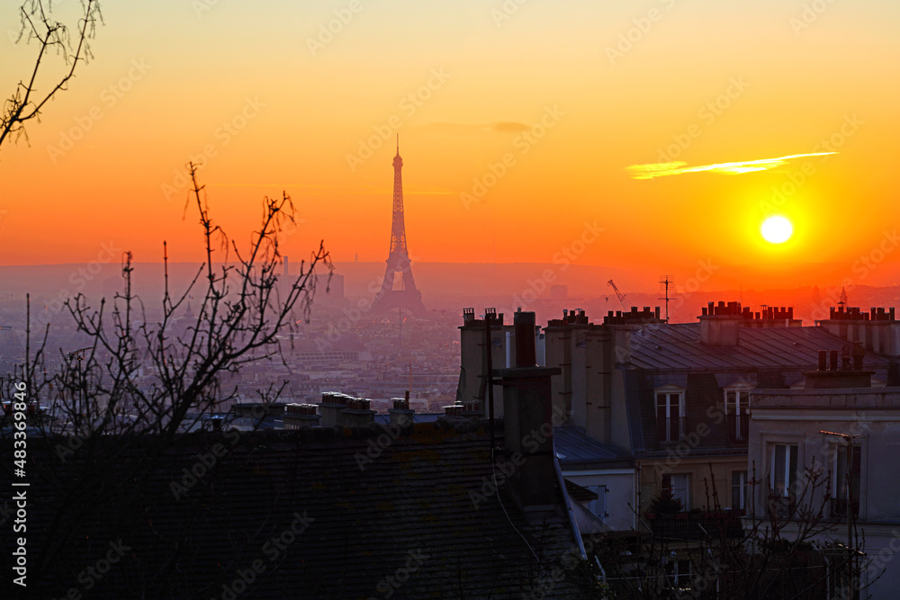 Sunset view of the Tour Eiffel tower, the most famous landmark in Paris, seen from the Montmartre neighborhood.