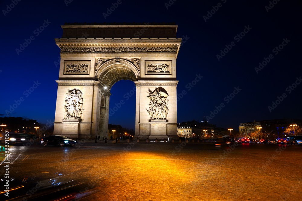 Night view of the Arc de Triomphe, a landmark monument on Place de l'Etoile and the Champs-Elysees in Paris, France.