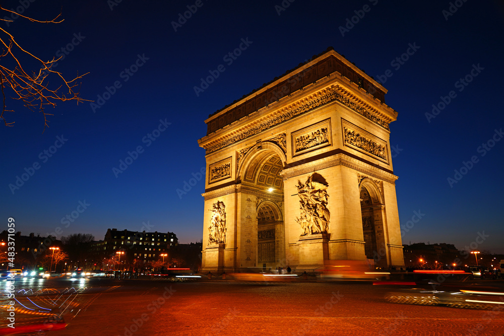 Night view of the Arc de Triomphe, a landmark monument on Place de l'Etoile and the Champs-Elysees in Paris, France.