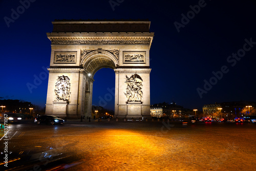 Night view of the Arc de Triomphe, a landmark monument on Place de l'Etoile and the Champs-Elysees in Paris, France. © eqroy