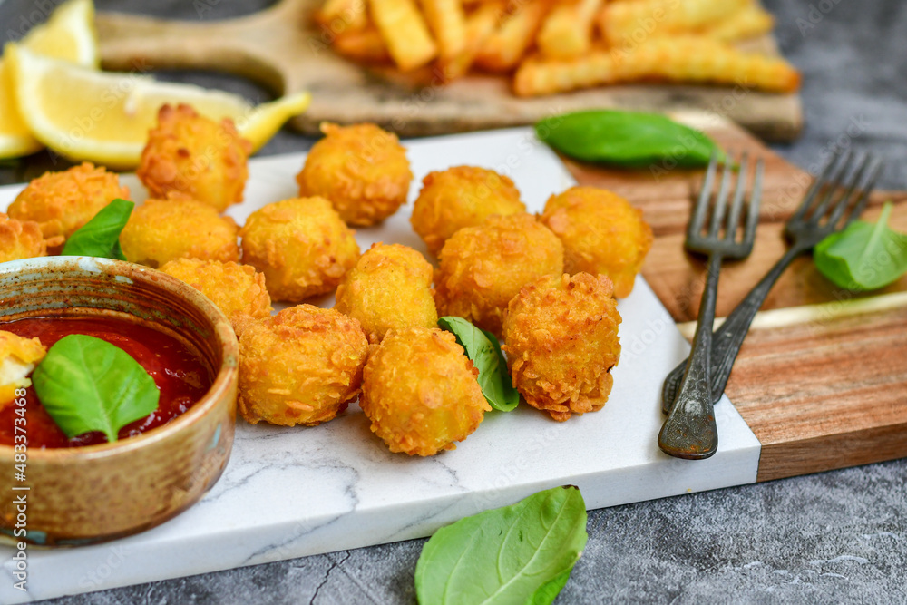Crispy  deep fried   chicken  nuggets . Breaded  with Cornflakes Breast fillets  with chilly peppers and fresh   basil on wooden rustic background
