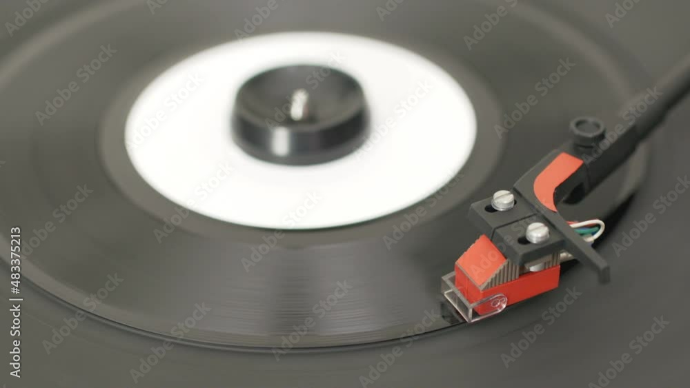 Closeup of female hand starting a retro record player with 7 inch vinyl record. Realtime video Closeup of female hand starting a retro record player with 7 inch vinyl record. Realtime video