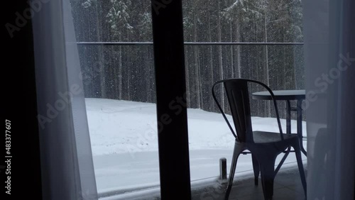 Cozy apartment in a winter hotel. Beautiful winter landscape outside the window. Pine forest in the snow