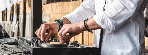 Horizontal banner with disc jockey playing music for tourist people at club party outdoors on the beach - Dj at music live event - Live event, music and fun concept - Entertainment and party concept