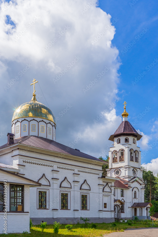 Church to St. Grand Prince Alexander Nevsky in Pudozh after restoration. Orthodox temple and bell tower against blue sky in summer sunny day. Karelia, Russia