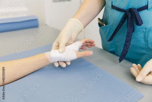 A doctor wrapped around the wrist for first aid close-up. Application of bandages on the patient's hands, first aid concepts and wrist injury treatment. Medical bandage on patient hand. Wrist pain