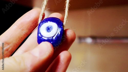 Cheshm nazar boncugu. In Turkic countries amulet against evil is also known as the evil eye. Blue glass amulet in woman's hand. Charm at home for protection from trouble. Symbol of good luck happiness photo
