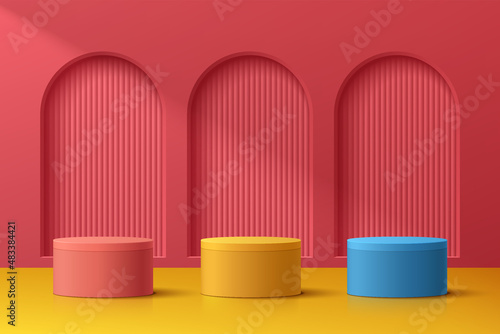 Abstract 3D room with realistic blue, yellow and red cylinder pedestal podium set on red arch door. Minimal scene for product display presentation. Vector geometric platform design. Stage for showcase