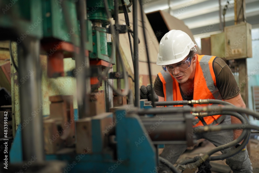 Industrial Engineers in Hard Hats.Work at the Heavy Industry Manufacturing Factory.industrial worker indoors in factory. man working in an industrial factory. Industrial Engineers in Hard Hats.Work at the Heavy Industry Manufacturing Factory.industrial worker indoors in factory. man working in an industrial factory.