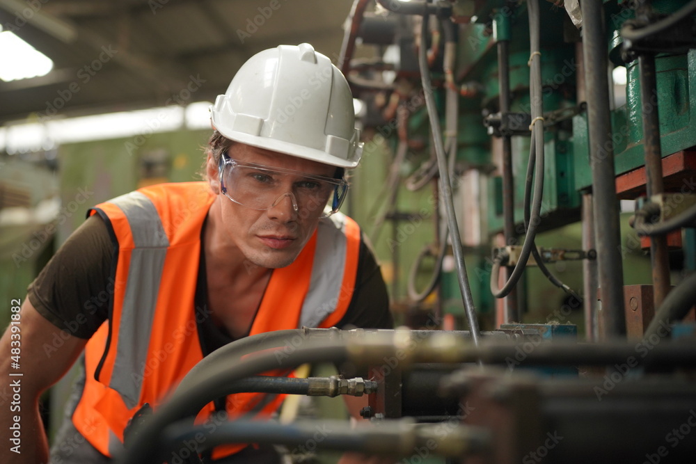 Industrial Engineers in Hard Hats.Work at the Heavy Industry Manufacturing Factory.industrial worker indoors in factory. man working in an industrial factory. Industrial Engineers in Hard Hats.Work at the Heavy Industry Manufacturing Factory.industrial worker indoors in factory. man working in an industrial factory.