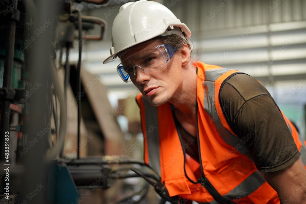 Industrial Engineers in Hard Hats.Work at the Heavy Industry Manufacturing Factory.industrial worker indoors in factory. man working in an industrial factory. Industrial Engineers in Hard Hats.Work at the Heavy Industry Manufacturing Factory.industrial worker indoors in factory. man working in an industrial factory.