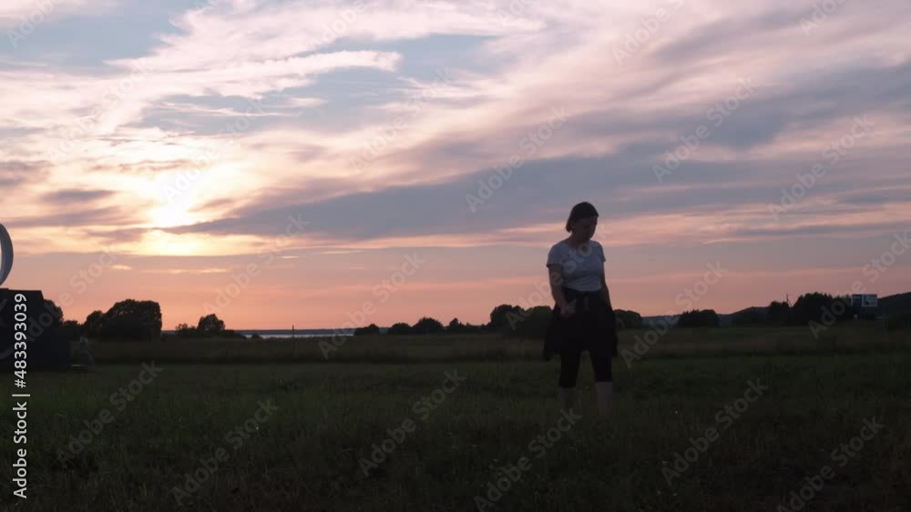 a young woman walks against a red sky background. sunset. journey. beautiful sunset. goes into the sunset a young woman walks against a red sky background. sunset. journey. beautiful sunset. goes into the sunset