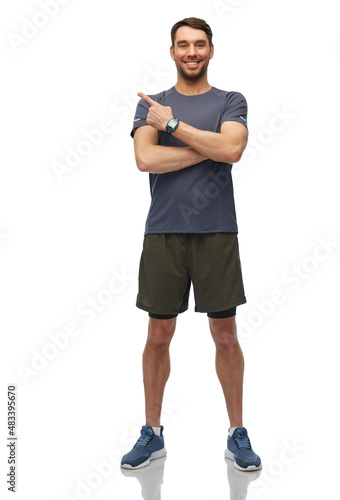 fitness, sport and healthy lifestyle concept - smiling man in sports clothes with smart watch or tracker showing something invisible over white background