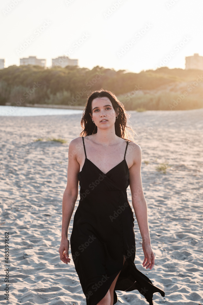 Slim attractive woman standing on sandy beach in sunny day Slim attractive woman standing on sandy beach in sunny day