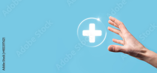 Businessman hold virtual plus medical network connection icons. Covid-19 pandemic develop people awareness and spread attention on their healthcare.