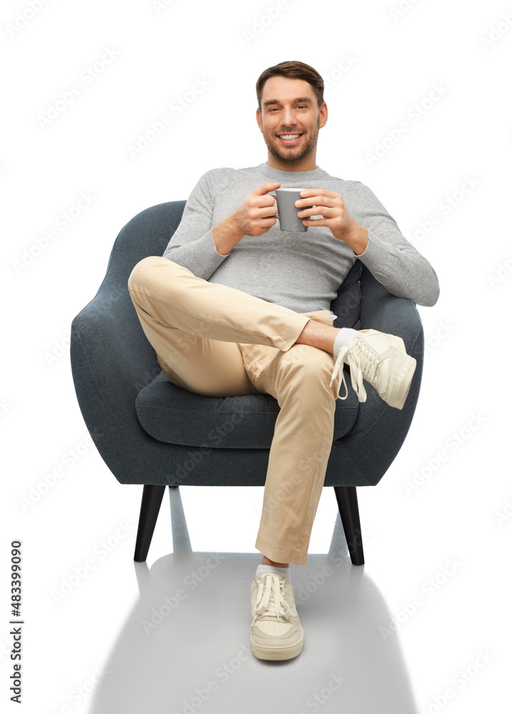 people and furniture concept - happy smiling man with cup of coffee or tea sitting in chair over white background
