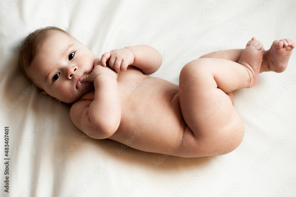 Soft picture of a beautiful baby boy 1-3 months laying on white bedding newborn photography Soft picture of a beautiful baby boy 1-3 months laying on white bedding newborn photography