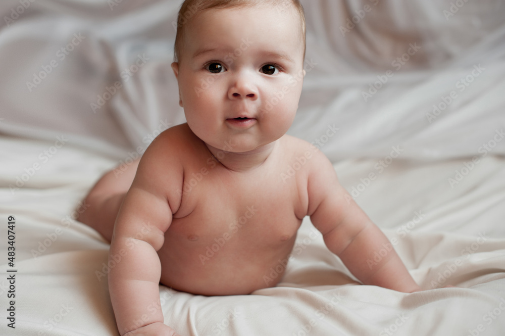 Soft picture of a beautiful baby boy 1-3 months laying on white bedding newborn photography Soft picture of a beautiful baby boy 1-3 months laying on white bedding newborn photography