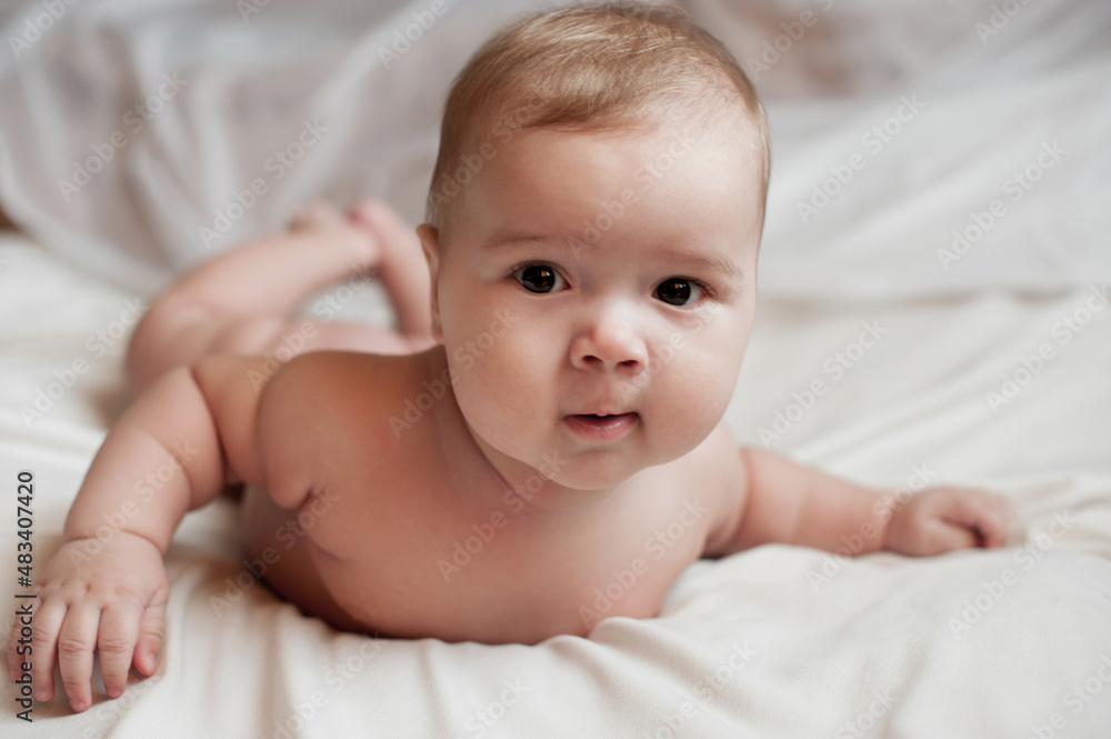 Soft picture of a beautiful baby boy 1-3 months laying on white bedding newborn photography Soft picture of a beautiful baby boy 1-3 months laying on white bedding newborn photography