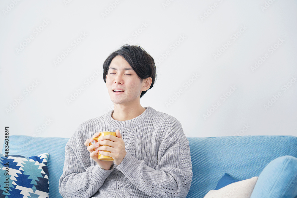 Fototapeta premium 男性 ホットドリンクを飲む リビング