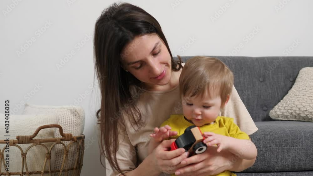 Young mother spends time in a modern cozy house with a little boy. A loving caring nanny plays with a preschooler in toy cars. Child development concept Young mother spends time in a modern cozy house with a little boy. A loving caring nanny plays with a preschooler in toy cars. Child development concept