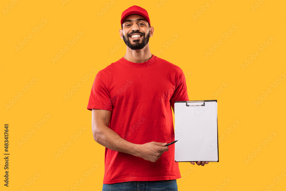 Arab Delivery Guy Showing Clipboard To Camera On Yellow Background Arab Delivery Guy Showing Clipboard To Camera On Yellow Background