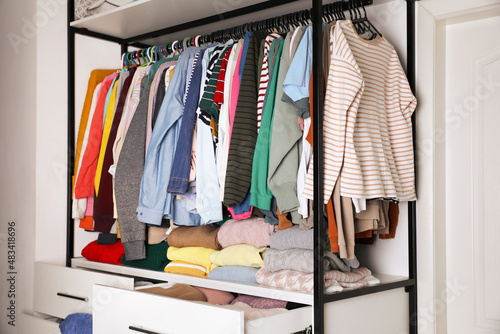 Rack with stylish women's clothes in room. Fast fashion