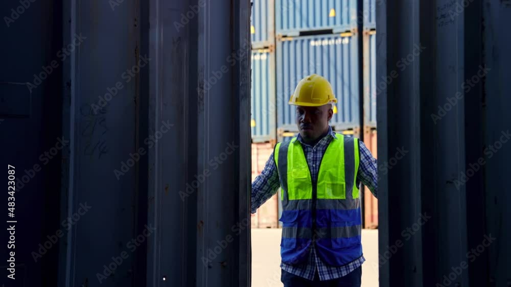 An African American foreman opened the container door to check the smoothness of the cargo before it was moved. Exporting abroad via cargo ships Supporting the concept of logistics transportation