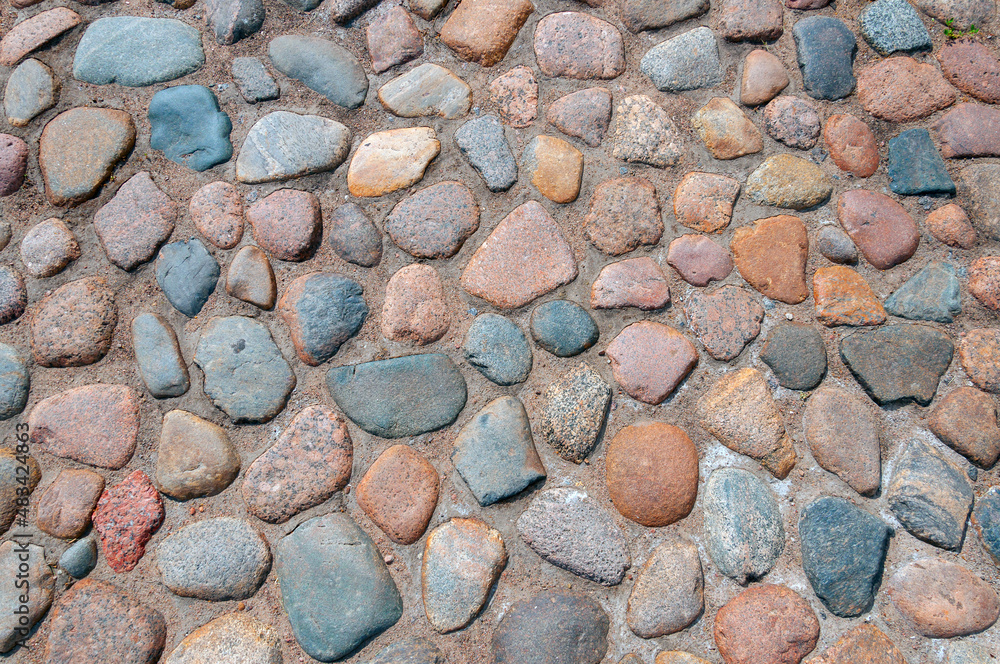 The texture or background is a sidewalk paved with cobblestones of different colors. Top view The texture or background is a sidewalk paved with cobblestones of different colors. Top view
