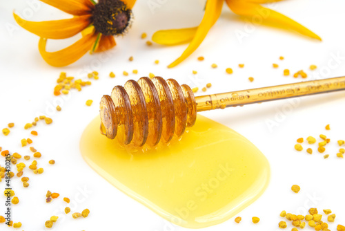 spoon with fresh honey and pollen spilled on a white background. organic vitamin food