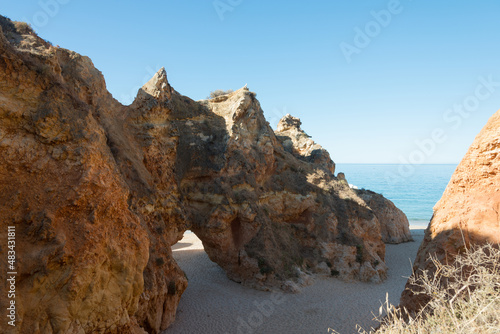 Beautiful natural limestone arch on a beach. Blue ocean in the background. Alvor, Portugal