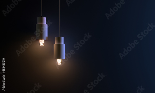 two pendant light bulbs burning on a dark and matt blue wall